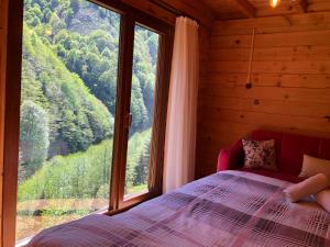 a bedroom with a bed and a large window at Ayder Şelale Apart in Ayder Yaylasi