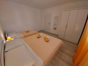 Apartments Marija في Draga Bašćanska: غرفة صغيرة بها سريرين وحوض استحمام