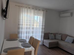 a living room with a table and a couch at Apartment Pocrnja in Rogoznica