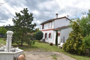 una casa blanca con un árbol y un patio en L'estanco, en Vieille-Brioude