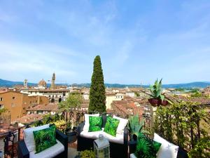a balcony with white and green pillows and a city at The View Of Sangiorgio in Florence