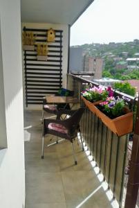 a balcony with a table and chairs and flowers at Lily`s Loft in Yerevan