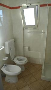 レウカにあるAttico Panoramicoのバスルーム(トイレ、窓、シャワー付)が備わります。