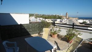 d'une table bleue et de chaises sur un balcon donnant sur l'océan. dans l'établissement Attico Panoramico, à Leuca
