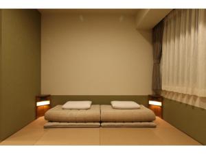 a bedroom with a bed with two pillows on it at Hotel Meldia Shijo Kawaramachi - Vacation STAY 86747 in Kyoto