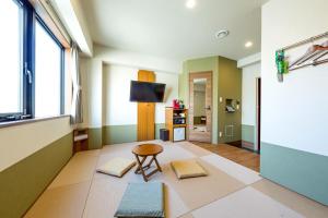 ein Wohnzimmer mit einem Tisch und einem TV in der Unterkunft Hotel Meldia Shijo Kawaramachi - Vacation STAY 86749 in Kyoto