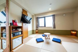 Zimmer mit 2 blauen Stühlen und einem TV in der Unterkunft Hotel Meldia Shijo Kawaramachi - Vacation STAY 86749 in Kyoto