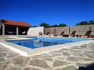 a swimming pool with chairs sitting next to a building at Kuća za odmor - My Soul in Šibenik