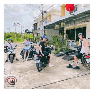 a group of people riding motorcycles on a street at Khaolak Mind Home Hostel in Khao Lak