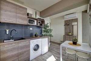 uma cozinha com uma máquina de lavar roupa e um lavatório em Familia Panzió & Apartmanház Győr em Gyor