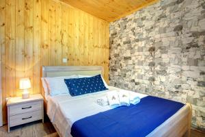 a bedroom with a bed and a stone wall at Terezina wood house in Kanakádes