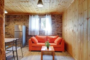 a living room with an orange couch and a table at Terezina wood house in Kanakádes