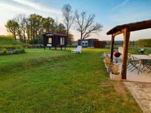 un patio trasero con cabina, mesa y sillas en Cocooning au Saut du Loup en Lavergne