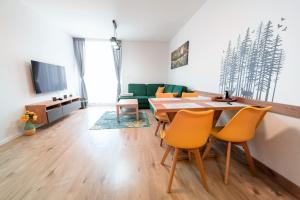 a living room with a dining room table and yellow chairs at Apartmán 110 Vila Zuberec in Zuberec