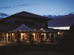 a hotel with tables and chairs in front of a building at Thorpe Park Hotel and Spa in Leeds