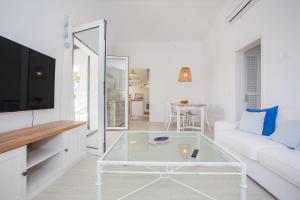 sala de estar con sofá blanco y mesa de centro de cristal en Villa Juanes en Ciutadella