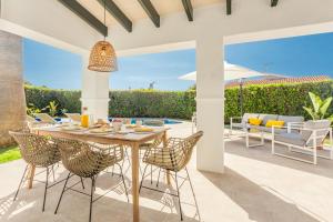 an outdoor dining room with a table and chairs at Villa Juanes in Ciutadella