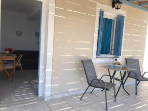 un patio con mesa y sillas junto a una pared en BAY VIEW STUDIO, en Megas Gialos - Nites