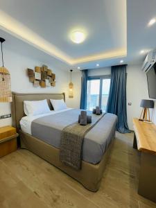 Frankie’s Sunrise villa في Agia Anna: غرفة نوم بسرير كبير مع ستائر زرقاء