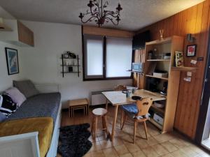 a bedroom with a table and a bed and a desk at Studio rénové Portes du Soleil Chatel Abondance in Abondance +12 photos