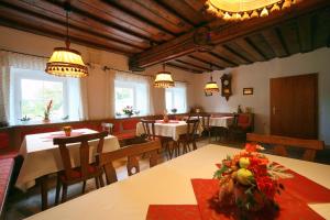 uma sala de jantar com mesas, cadeiras e luzes em Ferienhof am Landsberg em Obergrünburg