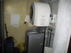 a laundry room with a dryer and a washing machine at Yukaina Nakamatachi in Yakushima