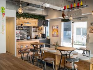 a restaurant with wooden tables and stools at Artist Hotel - BnA STUDIO Akihabara in Tokyo