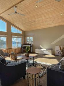a living room with a wooden ceiling and a piano at Ahmic Lake Resort in Magnetawan