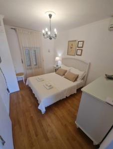 una camera da letto bianca con un letto e un lampadario di Holiday Home Little Heaven a Slatine Altre 27 foto