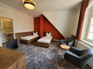 a hotel room with two beds and a table and chairs at Pension zum Kleistpark in Frankfurt Oder +37 photos