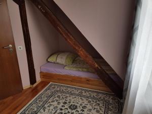 a small bed in a small room with a staircase at Mesonette Wohung in Hannover