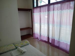 una camera con un letto e una grande finestra di Catalina`s Inn family room a Panglao