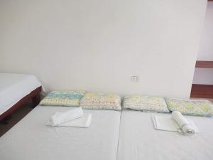 un letto bianco con cuscini sopra di Catalina`s Inn family room a Panglao
