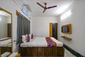 a bedroom with a bed and a ceiling fan at FabExpress Amar Raj Villa in Kolkata