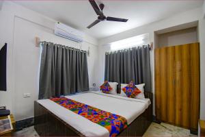 a bedroom with a bed and a ceiling fan at FabExpress Amar Raj Villa in Kolkata