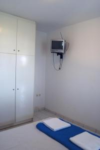 a room with a tv on the wall and a bed at BAY VIEW STUDIO in Megas Gialos - Nites