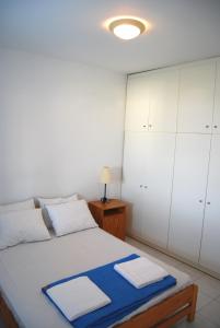 BAY VIEW STUDIO في Megas Gialos - Nites: غرفة نوم مع سرير مع دواليب بيضاء