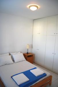 a bedroom with a bed with white cabinets at BAY VIEW STUDIO in Megas Gialos - Nites