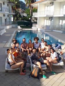 a group of people sitting on chairs by a swimming pool at Sarıgerme Apart in Sarigerme