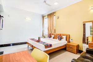 een kleine slaapkamer met een bed en een bank bij FabHotel Emara Grand in Bangalore