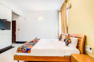 a bedroom with a bed and a television in it at FabHotel Emara Grand in Bangalore