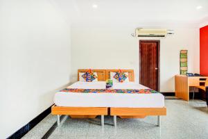 een slaapkamer met een bed en een bureau bij FabHotel Emara Grand in Bangalore