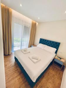 sypialnia z dużym łóżkiem z niebieskim zagłówkiem w obiekcie Garden Villas w mieście Donji Štoj