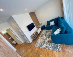 a living room with a blue couch and a television at Garden Villas in Donji Štoj
