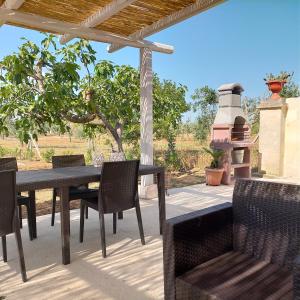 un patio con mesa, sillas y parrilla en M&M Luxury, en Maruggio