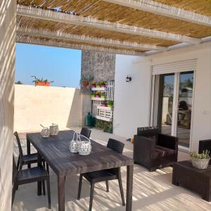 una mesa y sillas en un patio con vistas al océano en M&M Luxury, en Maruggio
