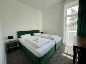 a bedroom with a green and white bed with a window at Green apartments Easy Kaunas in Kaunas