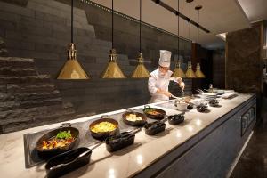 a chef preparing food in a restaurant kitchen at Lotte Hotel Seoul Executive Tower in Seoul