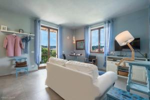 een woonkamer met een witte bank en blauwe muren bij Draisina Bike Apartments UNO in Oleggio Castello