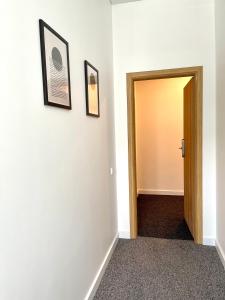 a hallway with two pictures on the wall and a door at Green apartments Easy Kaunas in Kaunas